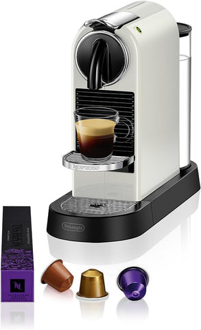 Nespresso coffee machine with a glass of espresso and capsules on a white background