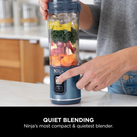 Ninja blender with ingredients being blended on a kitchen counter