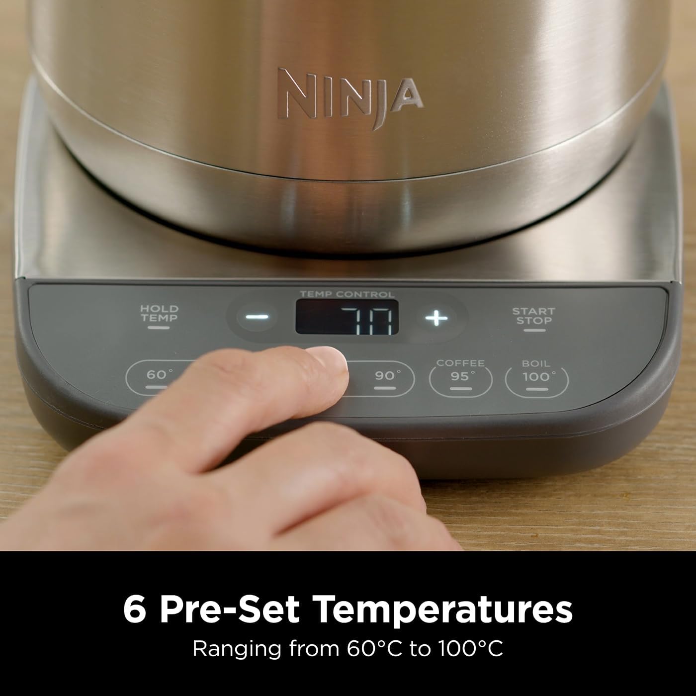 Ninja kitchen appliance with digital display and hand adjusting settings on a wooden surface.