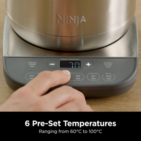 Ninja kitchen appliance with digital display and hand adjusting settings on a wooden surface.