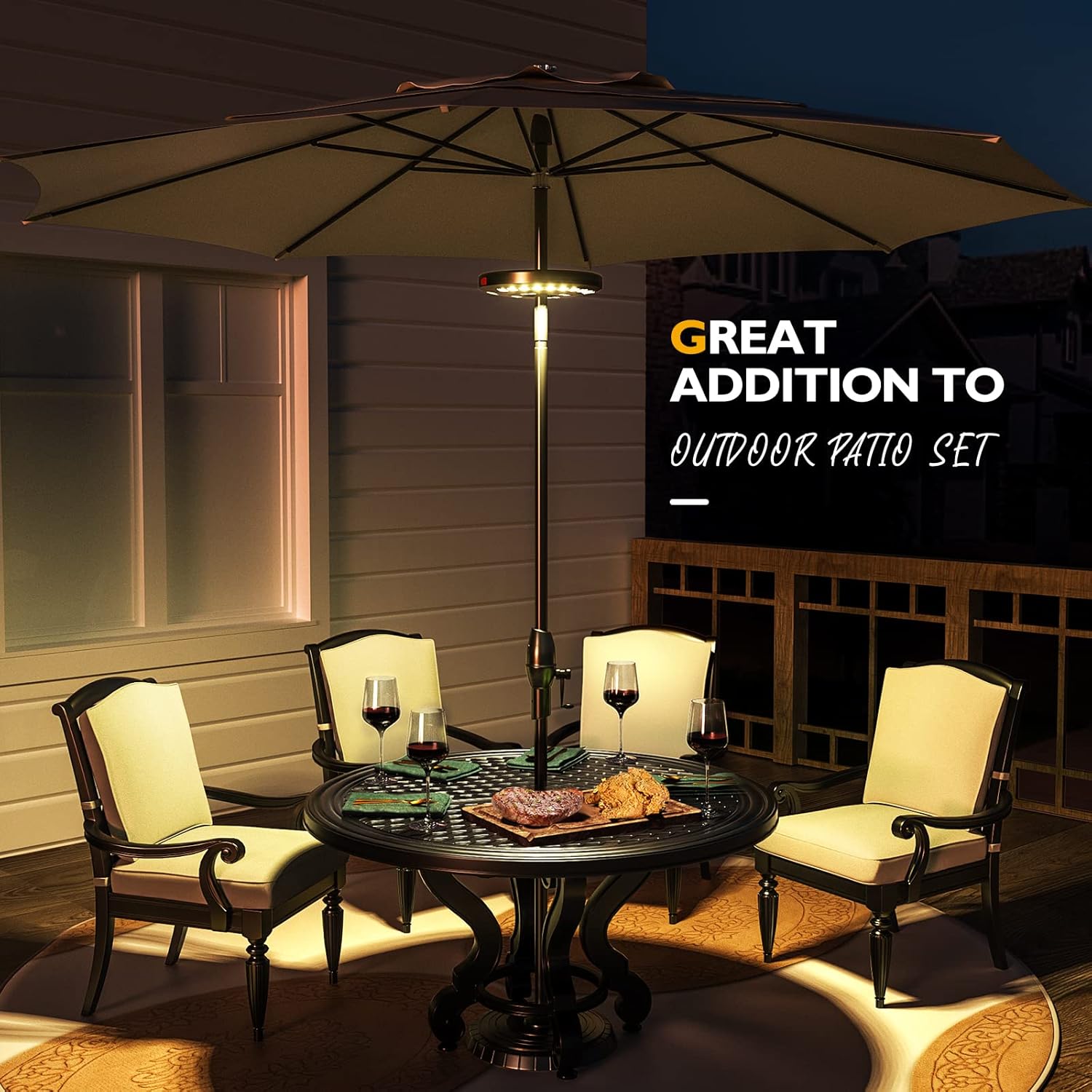 Outdoor patio set with table, chairs, and umbrella on a deck at night.