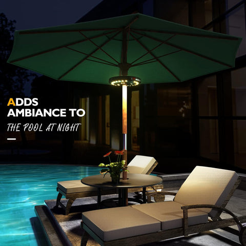 Outdoor patio setting with a green umbrella and lounge chairs by a pool at night.