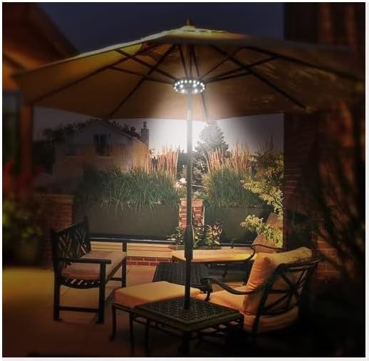 Outdoor patio setting with chairs, table, and large umbrella at night.