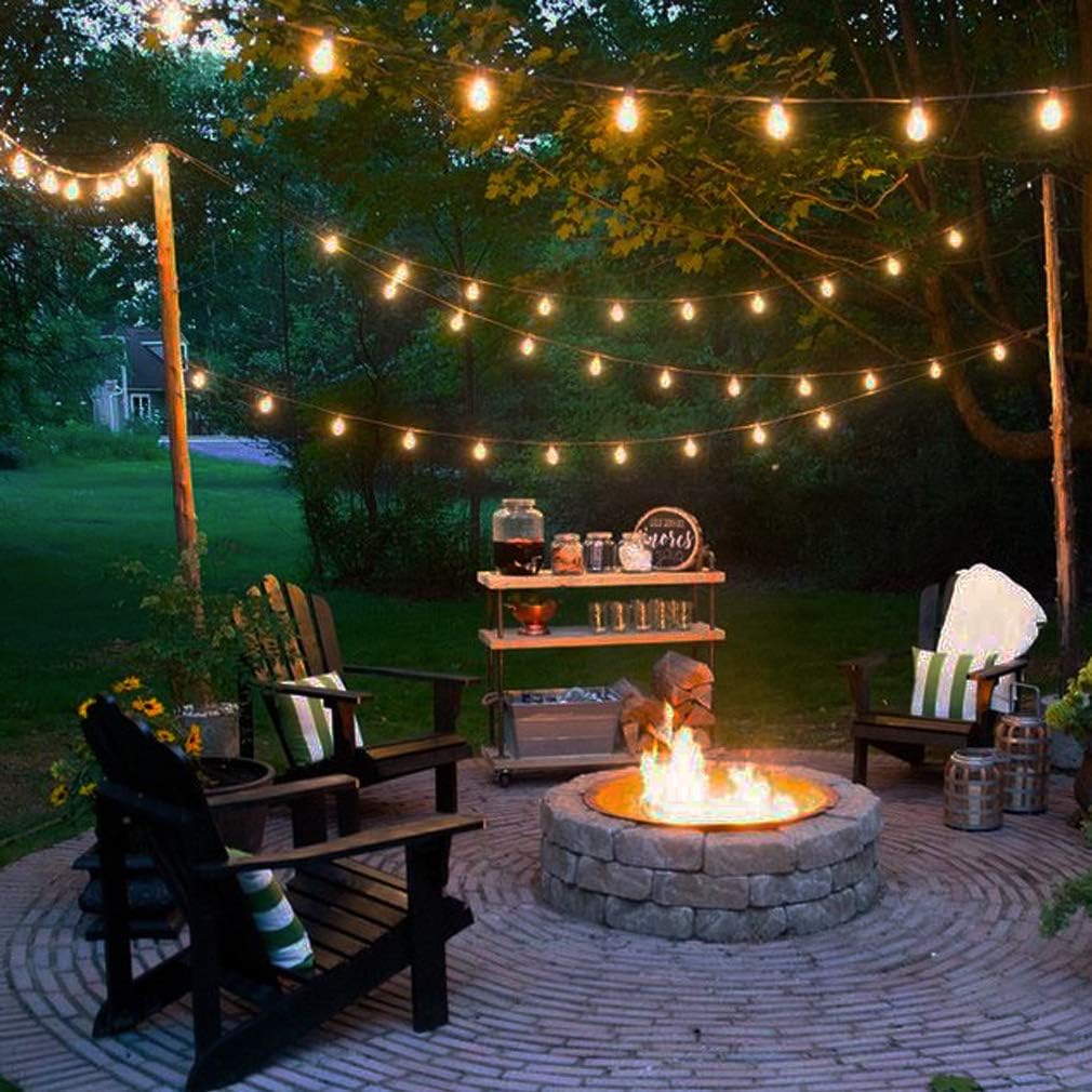 Outdoor patio with fire pit, string lights, and wooden chairs.