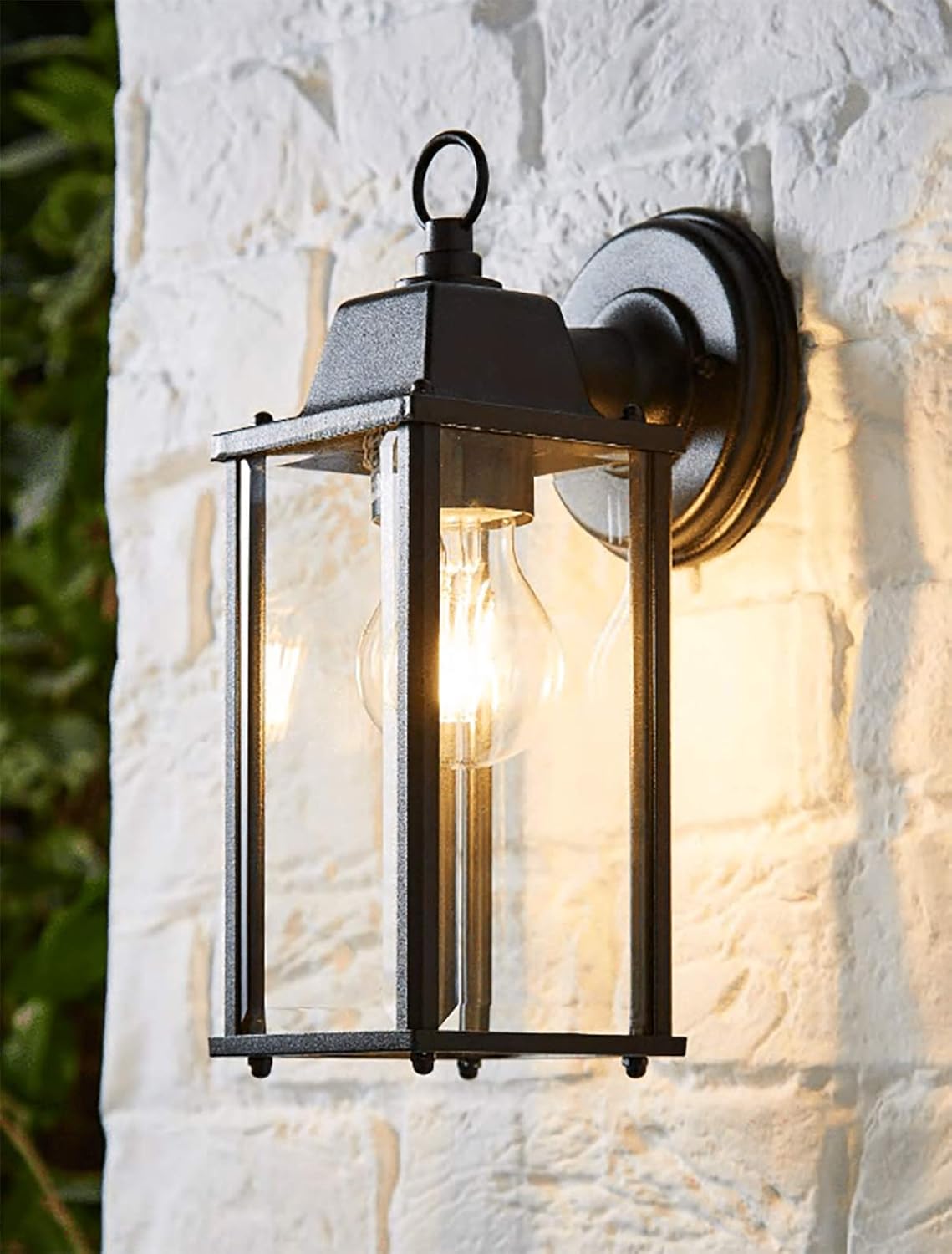 Outdoor wall light fixture on a textured white wall