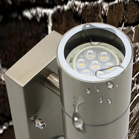 Outdoor wall light fixture with water droplets on a brick wall background