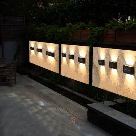 Outdoor wall lights illuminating a pathway at night