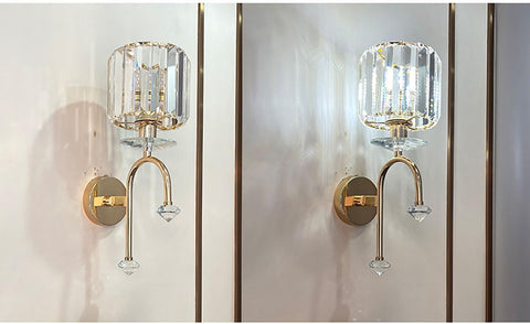 Pair of gold wall sconces with crystal accents on a neutral background