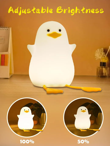 Penguin-shaped night light with adjustable brightness on a wooden surface.