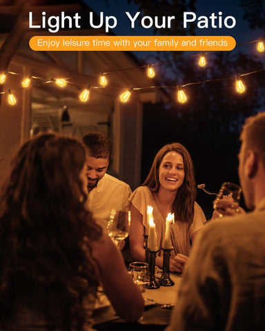 People enjoying a dinner party on a patio with string lights and candles.