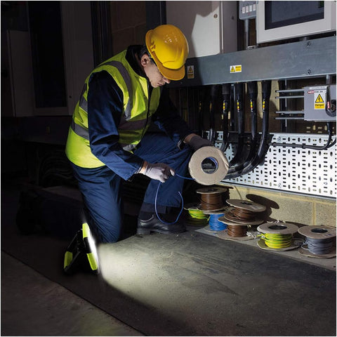 Person in safety gear working with spools of wire in a warehouse setting