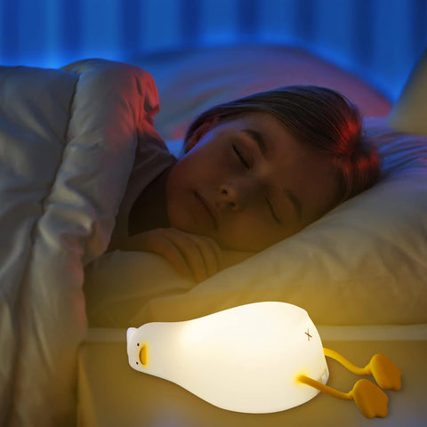 Person sleeping with a glowing night light on a bedside table