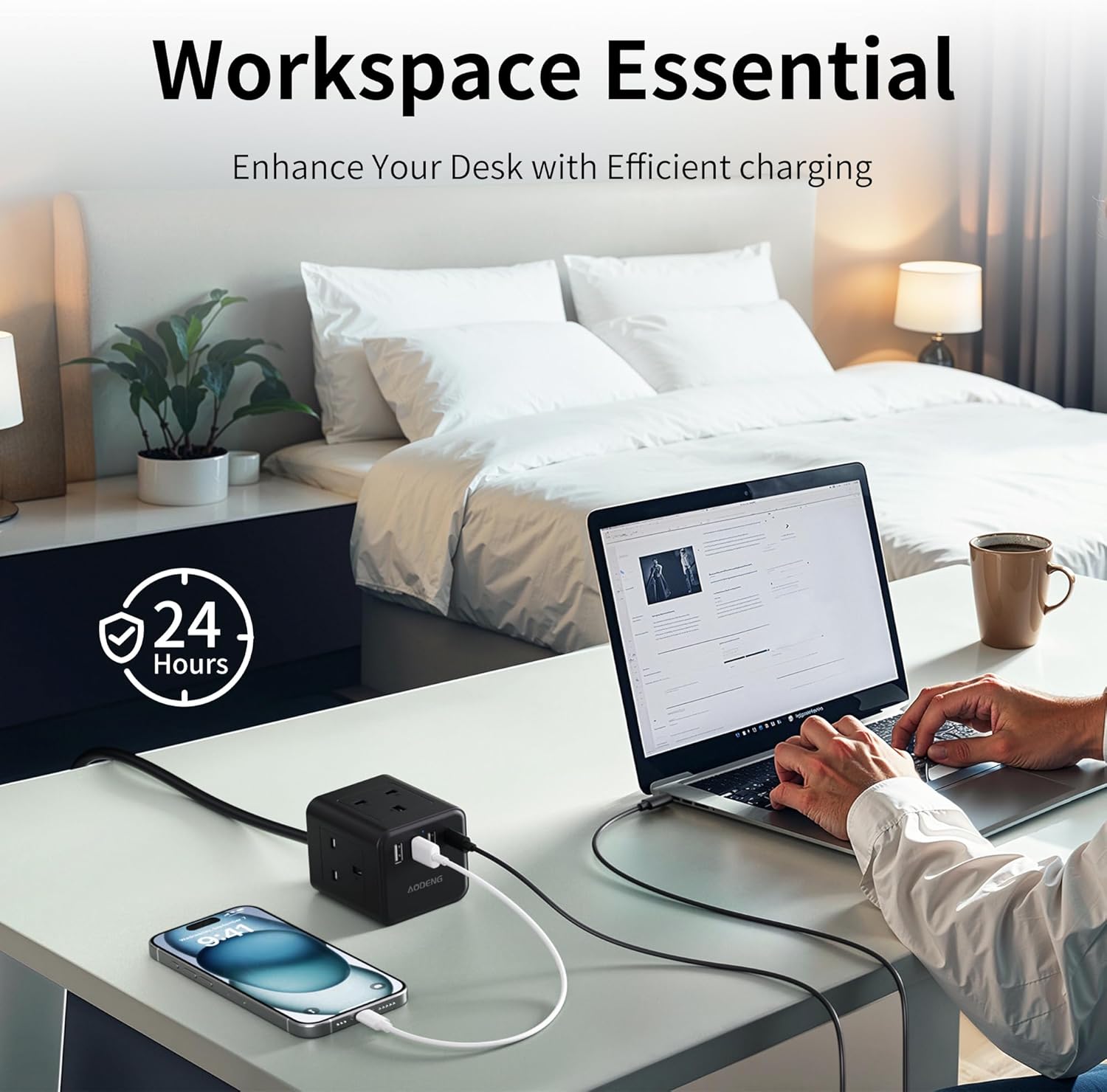 Person using a laptop on a desk with a power adapter and phone, bedroom in the background