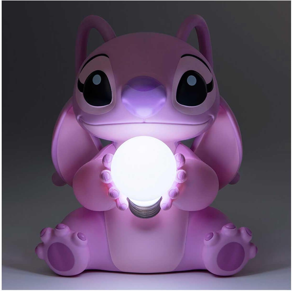 Pink cartoon-style lamp with a glowing light bulb on a dark background
