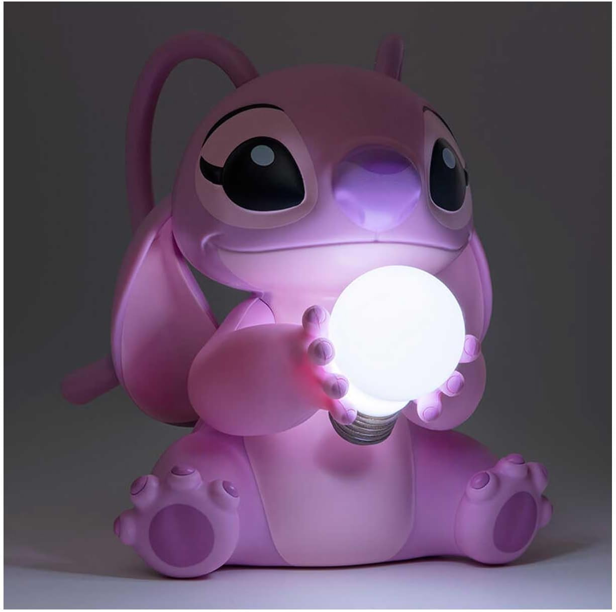 Pink cartoon character holding a glowing light bulb against a dark background