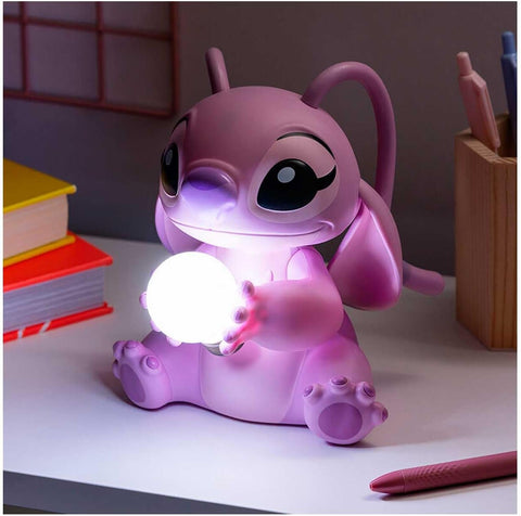 Pink cartoon dog-shaped night light on a desk with books and pens in the background
