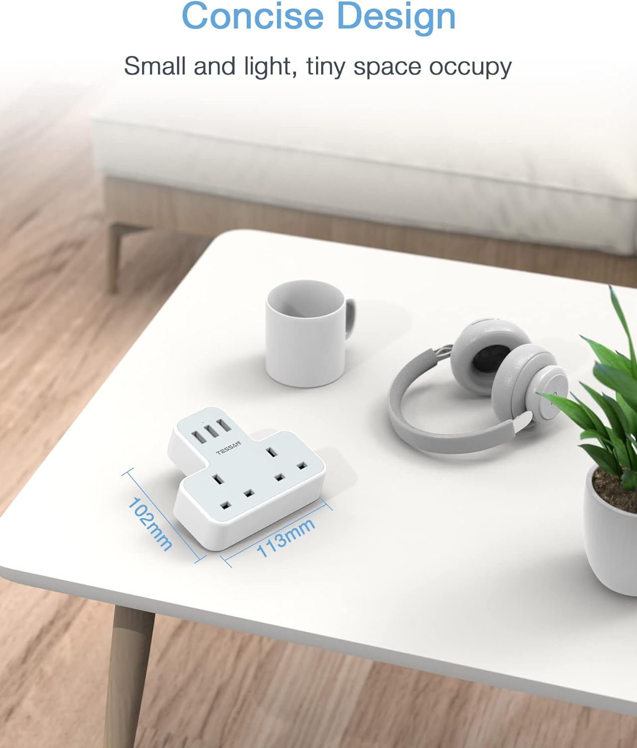 Small white power strip on a table with a cup and headphones, emphasizing its compact size.