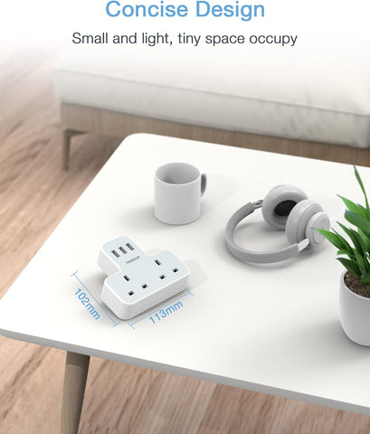 Small white power strip on a table with a cup and headphones, emphasizing its compact size.