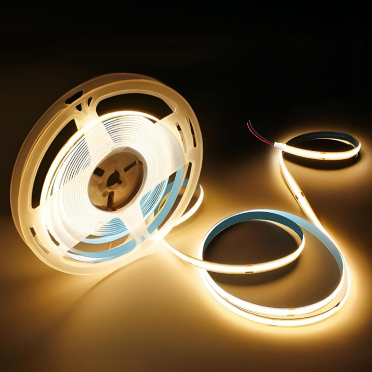Spool of LED strip light with warm glow on a dark background