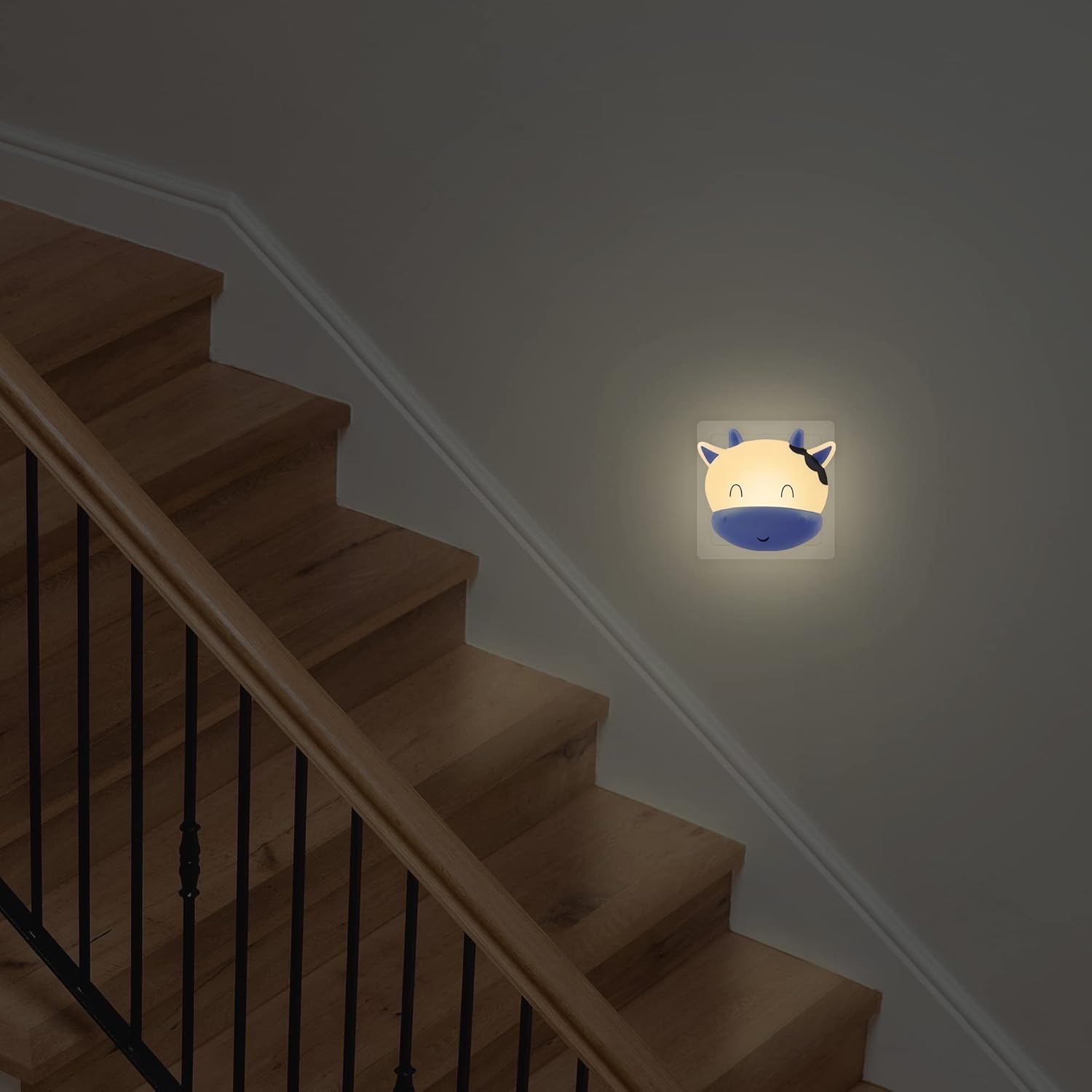 Staircase with a night light shaped like a cartoon face on the wall.
