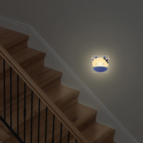 Staircase with a night light shaped like a cartoon face on the wall.