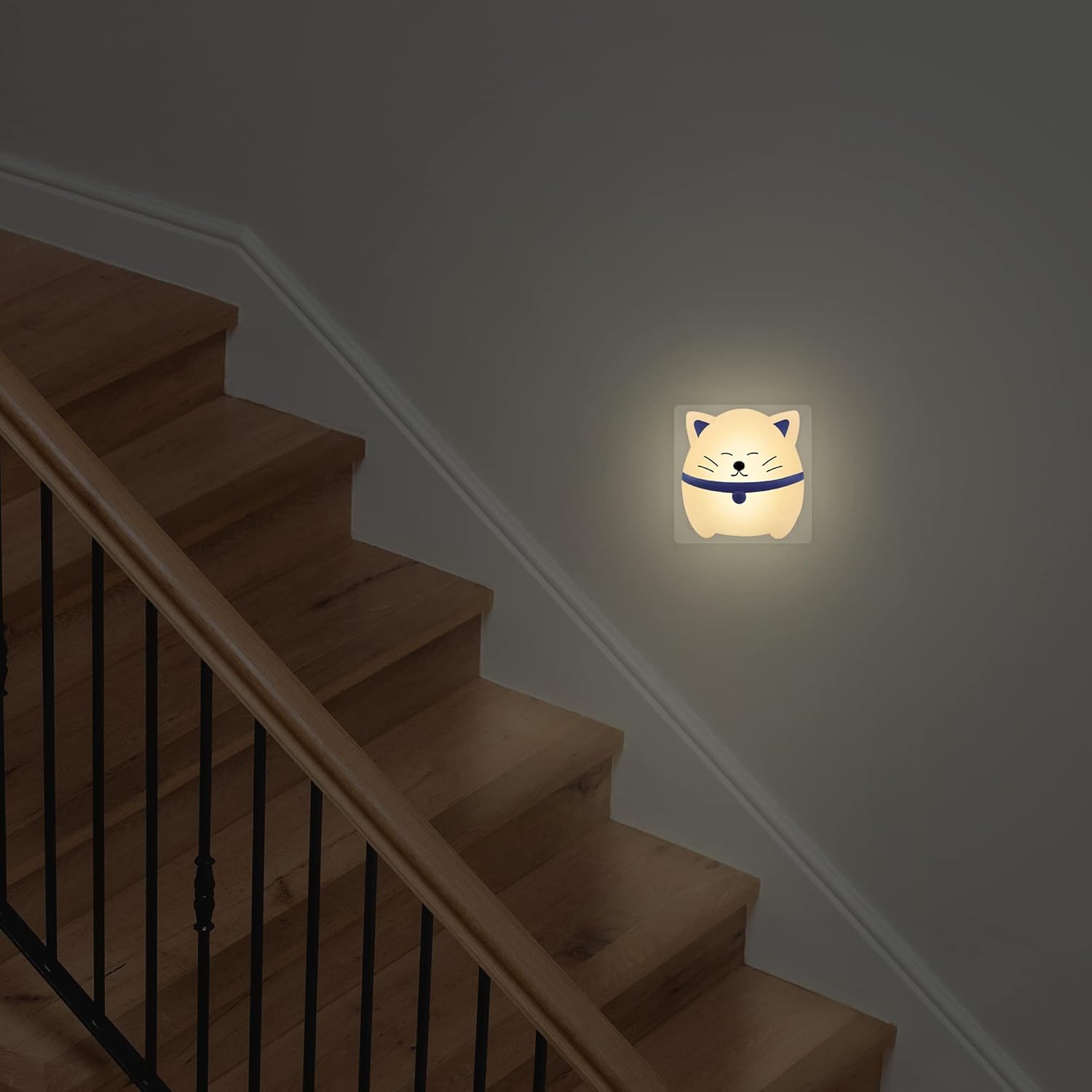 Staircase with a wall-mounted night light shaped like a cat's face.
