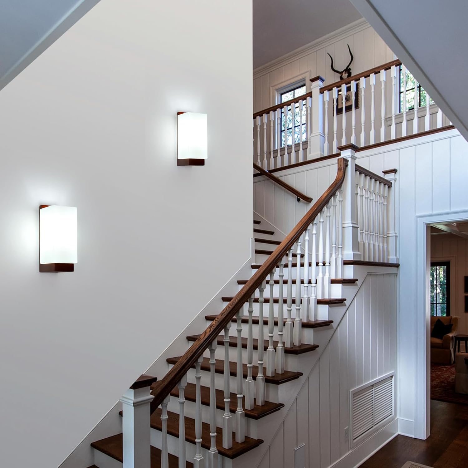 Staircase with wooden steps and white railings in a well-lit home interior.