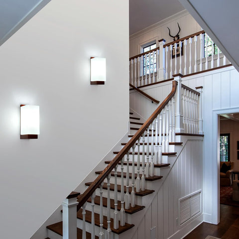 Staircase with wooden steps and white railings in a well-lit home interior.