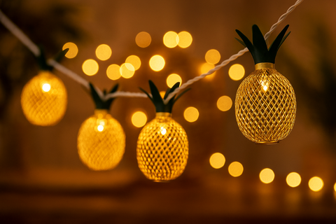 String lights shaped like pineapples with a blurred bokeh background
