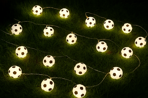String lights shaped like soccer balls on a dark background