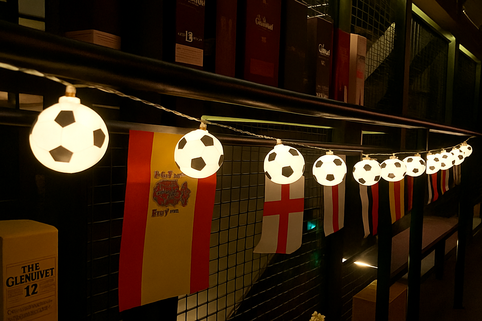 String lights shaped like soccer balls with Spanish and English flags hanging below.