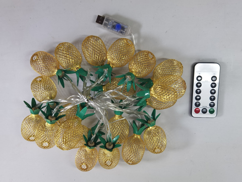 String lights with pineapple design, USB adapter, and remote control on a white background