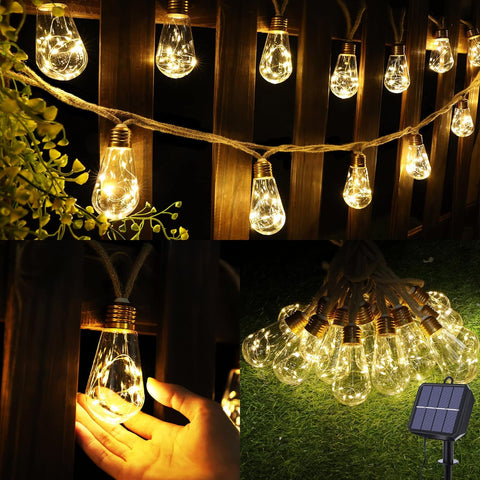 String of illuminated light bulbs with a hand holding one, set against a wooden wall and grassy ground.