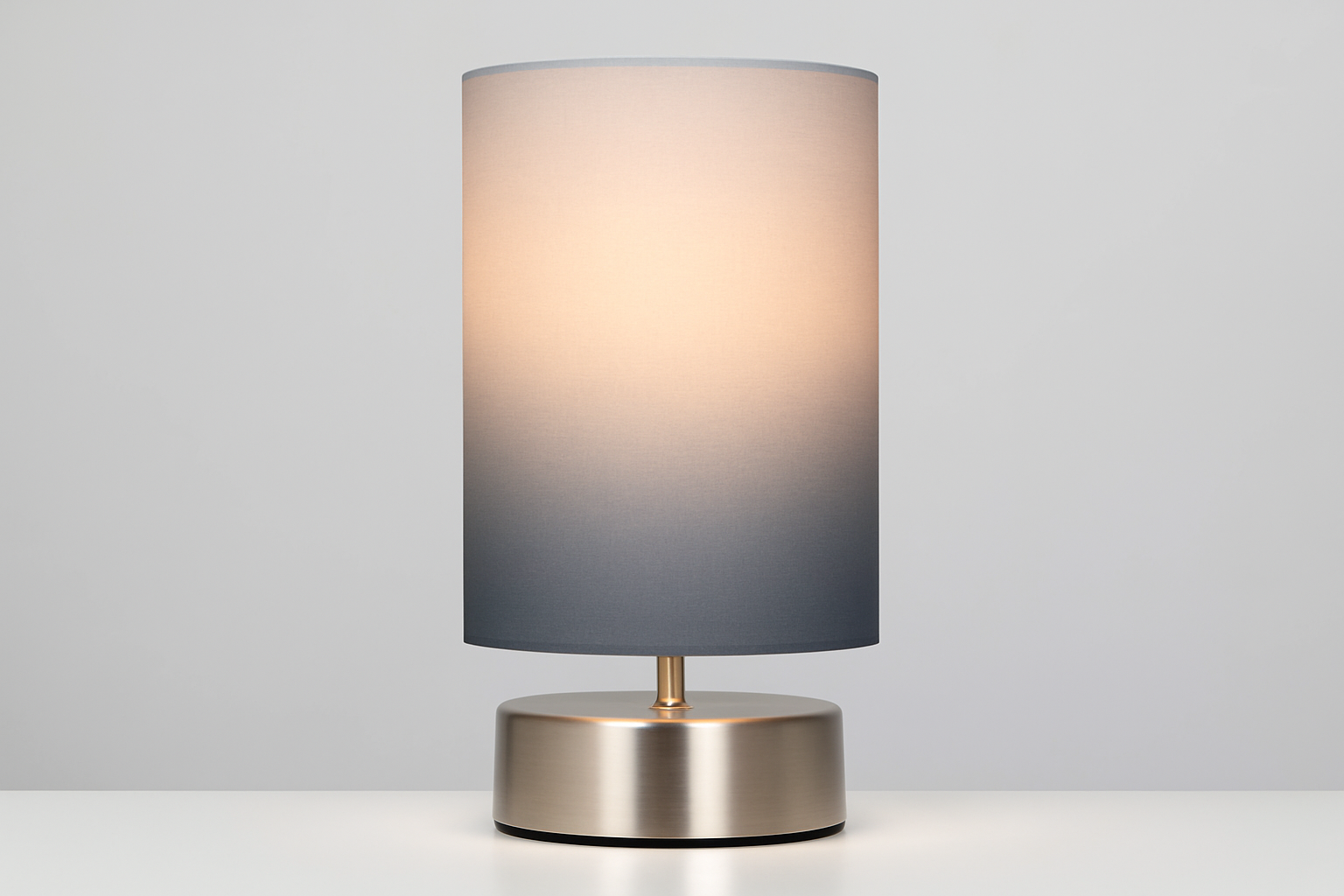 Table lamp with a gradient shade on a white surface and light gray background