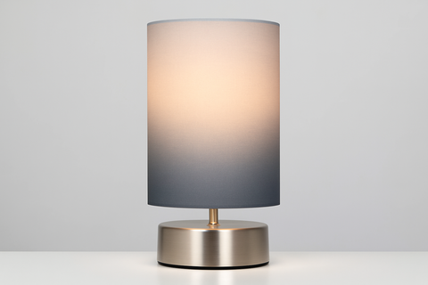 Table lamp with a gradient shade on a white surface and light gray background