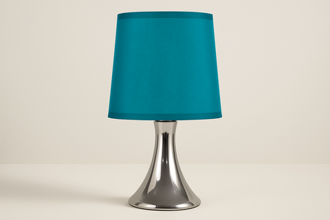 Table lamp with a teal shade and silver base on a beige background