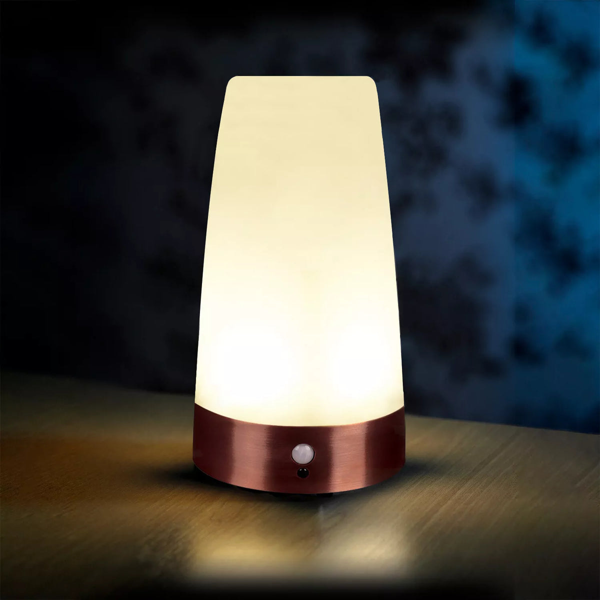 Table lamp with a warm glow on a wooden surface against a dark background