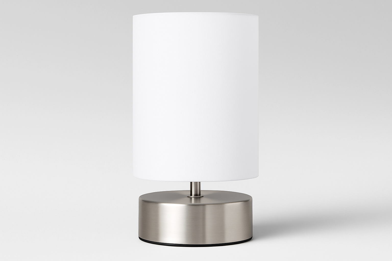 Table lamp with a white shade and metallic base on a light gray background