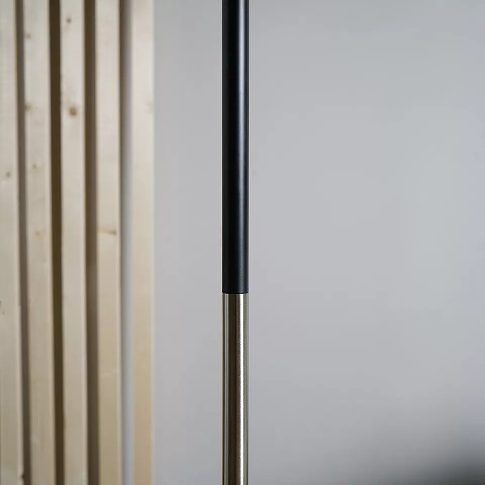 Tall industrial floor lamp enhancing the ambiance of a contemporary office.​

