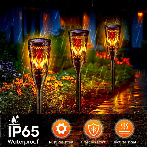 Three flame-patterned outdoor lights on a wet pavement with IP65, rust resistant, frost resistant, and heat resistant icons displayed.