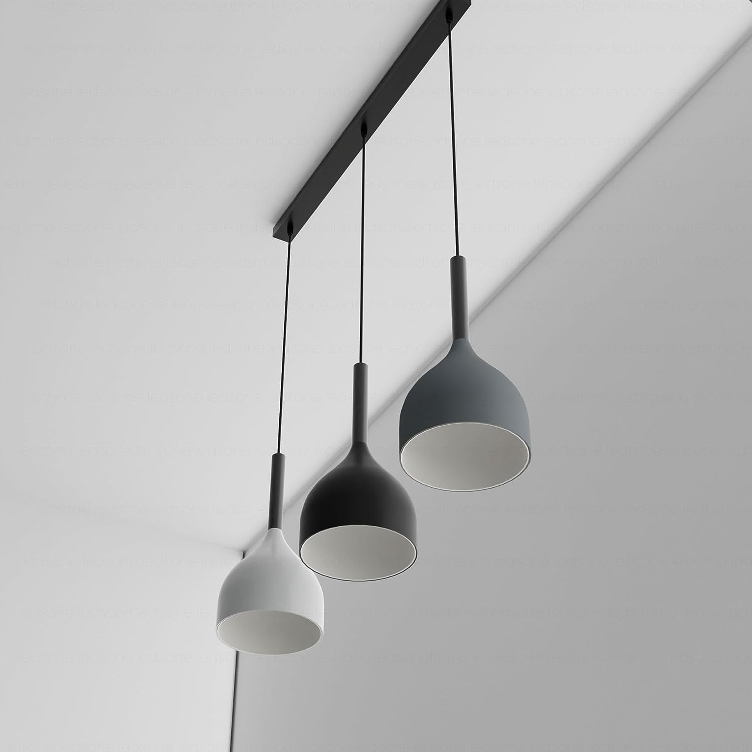 Three pendant lights hanging from a ceiling fixture against a plain background
