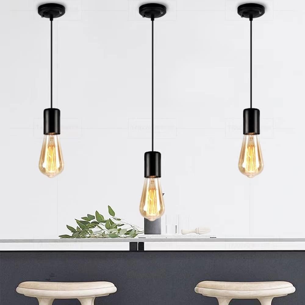 Three pendant lights with vintage-style bulbs hanging above a table with decorative elements.