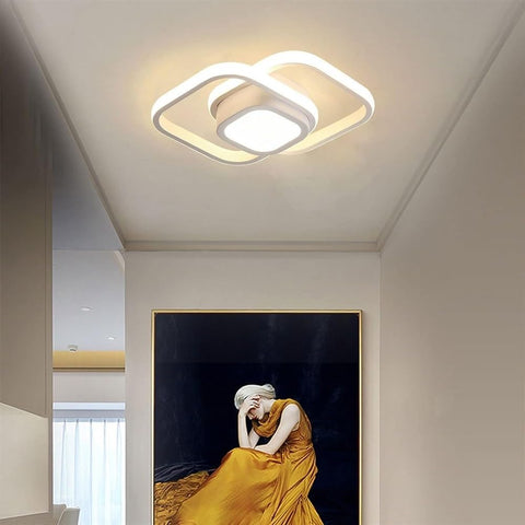 Modern ceiling light fixture in a room with a painting of a woman in a yellow dress.