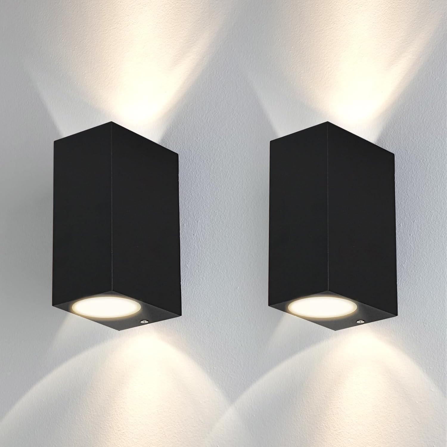 Two black square wall lights on a white wall