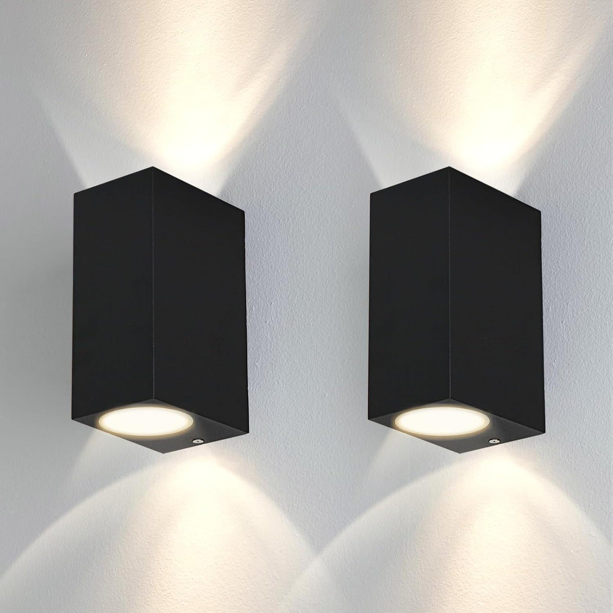 Two black square wall lights on a white wall