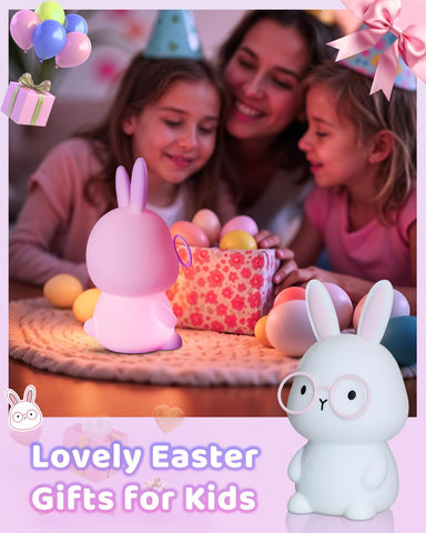 Two children and a woman with Easter eggs and a pink bunny-shaped gift on a table.