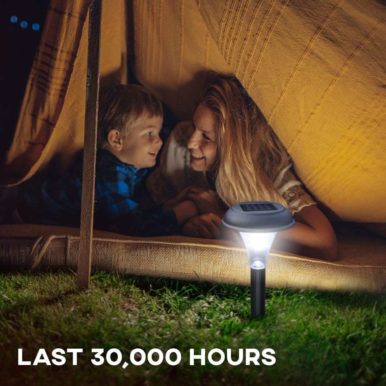 Two children in a tent with a solar lamp on the ground, indicating a long-lasting product.