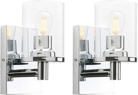 Two chrome wall sconces with clear glass shades on a white background