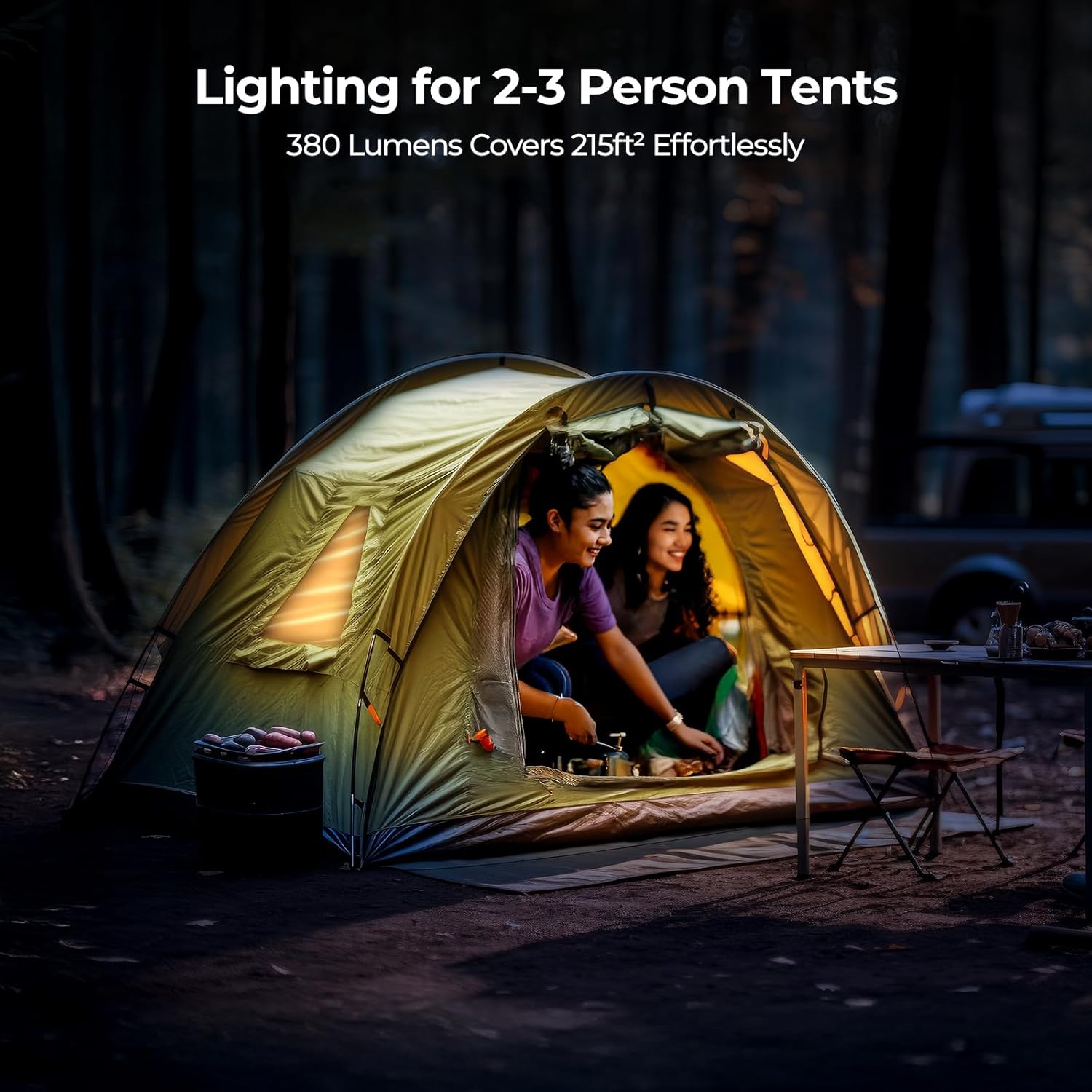 Two people inside a tent with lighting equipment, set against a dark forest background.