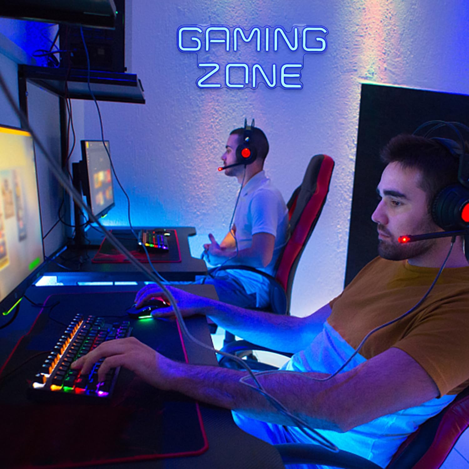 Two people playing video games in a room with 'Gaming Zone' sign.